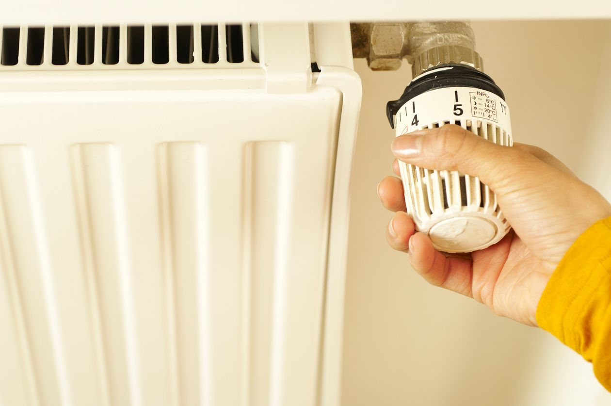 Ręka regulująca zawór grzejnika, efektywność energetyczna mieszkania