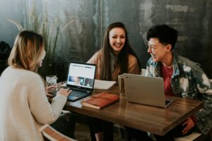 Studenci uczący się razem przy laptopach w mieszkaniu studenckim