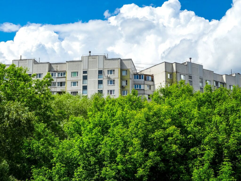 Budynki mieszkalne otoczone bujną zielenią, osiedle odporne na upały