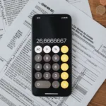 Formularze podatkowe i kalkulator na drewnianym blacie, ilustracja do tekstu o trzeciej racie podatku od nieruchomości