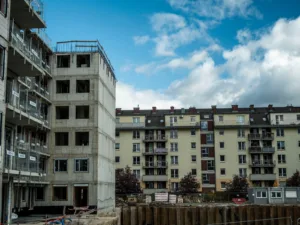 Plac budowy nowego budynku mieszkalnego obok gotowych bloków we Wrocławiu