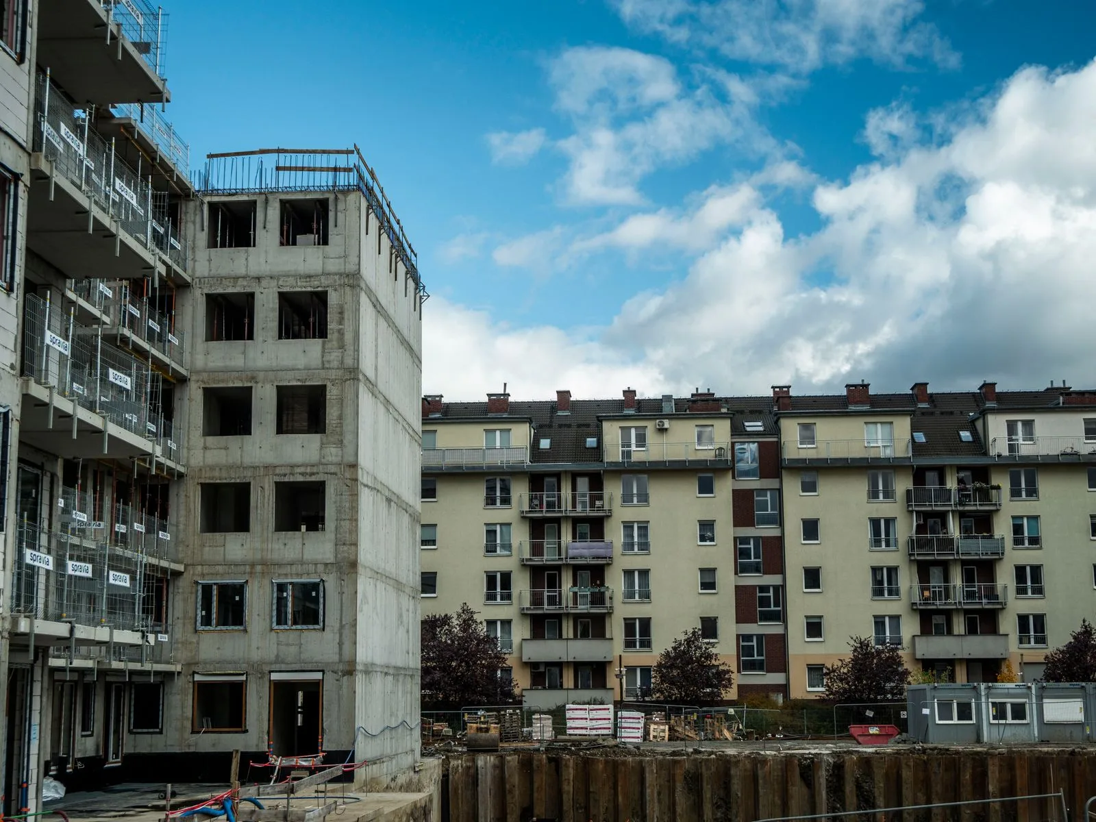 Plac budowy nowego budynku mieszkalnego obok gotowych bloków we Wrocławiu