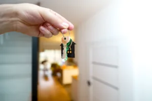 Dłoń trzymająca klucze do mieszkania w drzwiach apartamentu