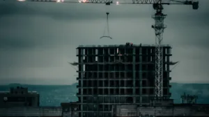 Wieżowiec mieszkalny w budowie z dźwigiem na tle miasta