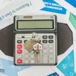Kalkulator, klucze do mieszkania i dokumenty kredytu hipotecznego na stole